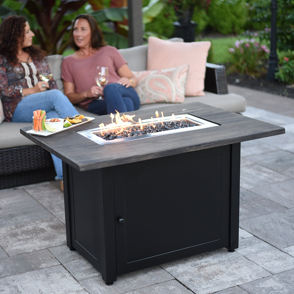 Endless Summer Marc Rectangular LP Outdoor Gas Fire Pit Table - two friends chatting around the fire pit