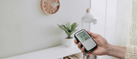 3 Warning Signs Your Home Needs an Air Quality Monitor- Person testing air quality with a monitor