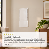 A white wall-mounted Santa Fe In-Wall Dehumidifier (UltraMD33) panel shown in a styled interior, with a large review overlay at the bottom containing a five-star rating and customer text I bought 3 - well made.
