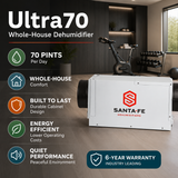 A white Santa Fe Ultra70 whole-house dehumidifier shown in a modern home gym interior, with feature callouts on the left including 70 pints per day, whole-house comfort, innovative cabinet design, energy efficiency, quiet performance, and a 6-year warranty.
